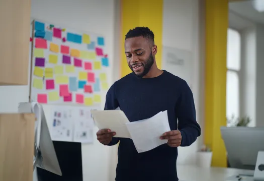 Un étudiant lit des documents dans un espace de travail coloré